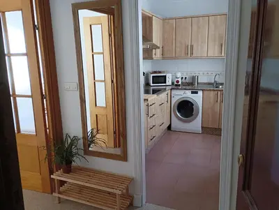 a kitchen with a washer and dryer at Ático primera línea de playa con vistas al Mar-Climatizado-Wifi-Parking-Solo familias in El Puerto de Santa María