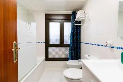 a white bathroom with a toilet and a window at Casa San Lucas - Corazón del Casco Histórico con piscina y parking in Jerez de la Frontera