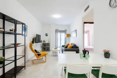 a living room with a white table and yellow chairs at Casa San Lucas - Corazón del Casco Histórico con piscina y parking in Jerez de la Frontera