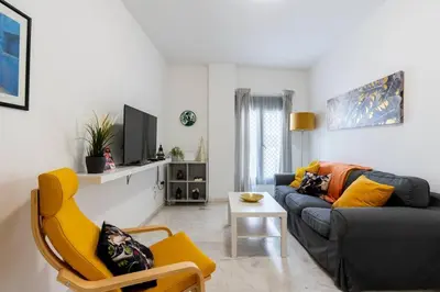 a living room with a couch and a yellow chair at Casa San Lucas - Corazón del Casco Histórico con piscina y parking in Jerez de la Frontera