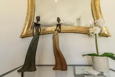 a mirror hanging on a wall next to a vase with flowers at Allo Apartments Santa Maria I Centro 1 Habitación in Jerez de la Frontera