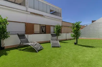two chairs sitting on a lawn in front of a building at Allo Apartments Santa Maria I Centro 1 Habitación in Jerez de la Frontera