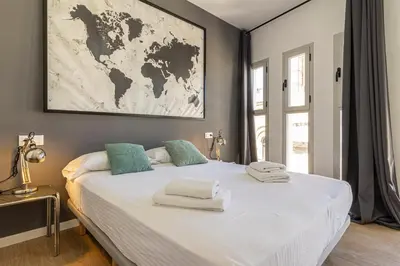 a bedroom with a large bed with towels on it at Allo Apartments Santa Maria I Centro 1 Habitación in Jerez de la Frontera