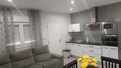 a living room with a couch and a kitchen at Villa nazaret in Chiclana de la Frontera