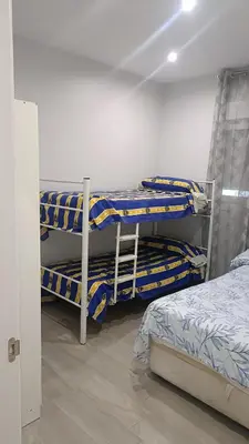 a room with three bunk beds and a ladder at Villa nazaret in Chiclana de la Frontera