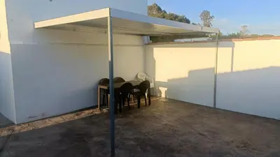 a patio with a table and chairs under a canopy at Villa nazaret in Chiclana de la Frontera