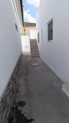 a hallway of a white building with a stair case at Villa nazaret in Chiclana de la Frontera