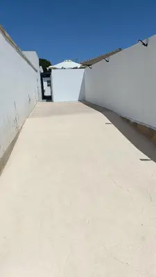 a large empty patio with a white wall at Villa nazaret in Chiclana de la Frontera