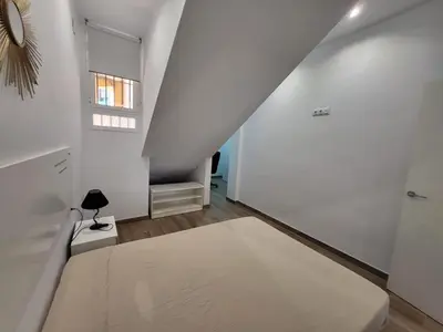 a white room with a bed and a window at Apartamento Parque Bahía in Puerto Real