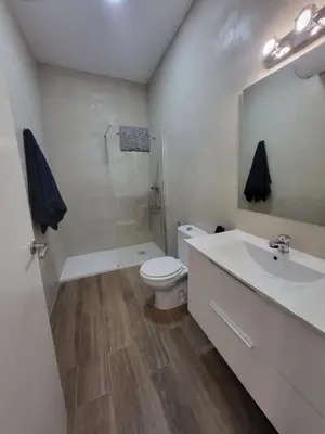 a white bathroom with a toilet and a sink at Apartamento Parque Bahía in Puerto Real