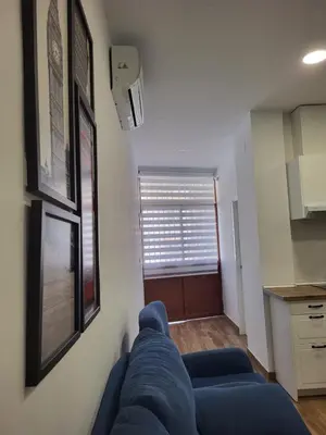a blue couch in a living room with a window at Apartamento Parque Bahía in Puerto Real