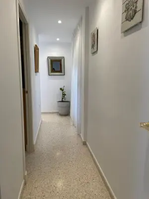 a hallway with a toilet in a white room at ÁTICO BAJO GUÍA in Sanlúcar de Barrameda