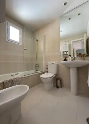 a bathroom with a toilet and a sink and a shower at ÁTICO BAJO GUÍA in Sanlúcar de Barrameda