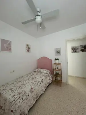 a bedroom with a bed and a ceiling fan at ÁTICO BAJO GUÍA in Sanlúcar de Barrameda