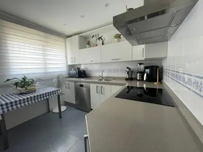 a kitchen with white cabinets and a counter top at ÁTICO BAJO GUÍA in Sanlúcar de Barrameda