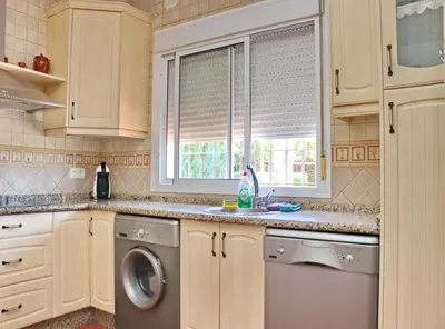 a kitchen with a washing machine and a window at Casa El Oasis in Conil de la Frontera