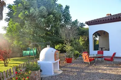 a backyard with a garden with a grill and a table at Casa El Oasis in Conil de la Frontera