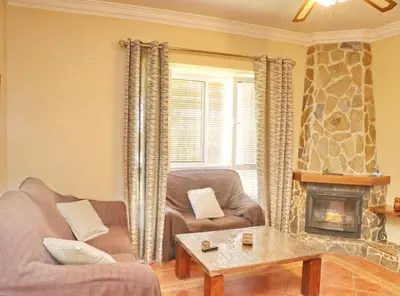 a living room with two chairs and a fireplace at Casa El Oasis in Conil de la Frontera