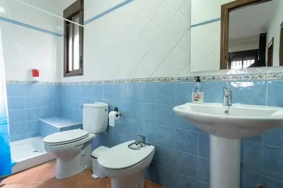 a blue tiled bathroom with a toilet and a sink at EntreCalas 2 Chalet con piscina privada en Conil, Roche viejo, cala del aceite in Conil de la Frontera