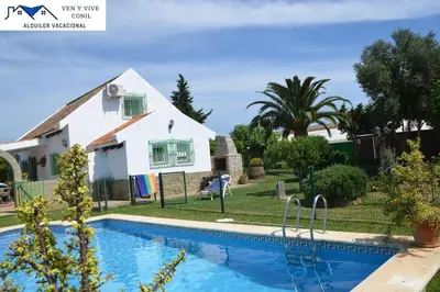 a villa with a swimming pool in front of a house at Villa Aurora in Cádiz