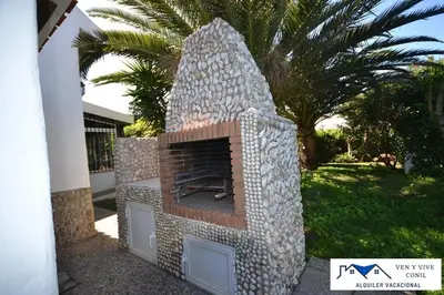 a stone fireplace in front of a house at Villa Aurora in Cádiz