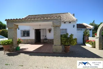 a white house with a gate and a patio at Villa Aurora in Cádiz