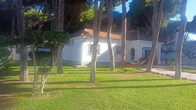 a house with a hammock in front of a yard at La Morena 68 in Chiclana de la Frontera