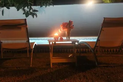two chairs and a table with a candle on the grass at La Morena 68 in Chiclana de la Frontera