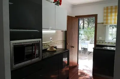 a kitchen with black cabinets and a microwave at La Morena 68 in Chiclana de la Frontera