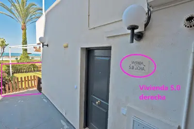 a door to a building with a sign on it at On Beach Deluxe Apartment with Pools and own Garden in El Puerto de Santa María