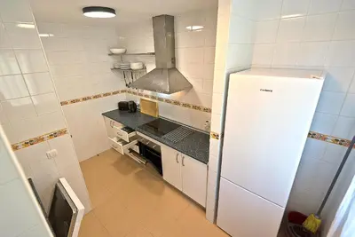 a kitchen with a refrigerator and a stove at On Beach Deluxe Apartment with Pools and own Garden in El Puerto de Santa María