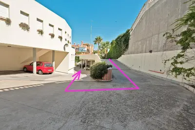 a parking lot with a potted plant next to a building at On Beach Deluxe Apartment with Pools and own Garden in El Puerto de Santa María