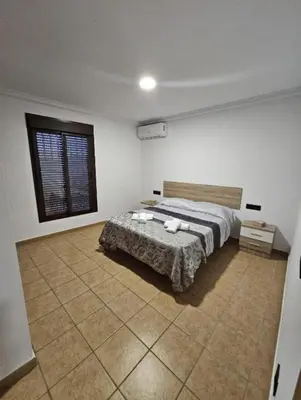 a bedroom with a bed in a room with a window at Casa piscina in Chiclana de la Frontera