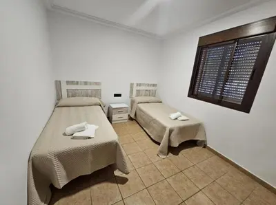 a bedroom with two beds and a window at Casa piscina in Chiclana de la Frontera