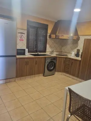 a kitchen with a refrigerator and a washing machine at Casa piscina in Chiclana de la Frontera