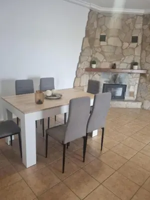 a dining room with a table and chairs and a fireplace at Casa piscina in Chiclana de la Frontera