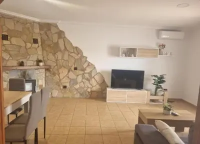 a living room with a stone wall at Casa piscina in Chiclana de la Frontera