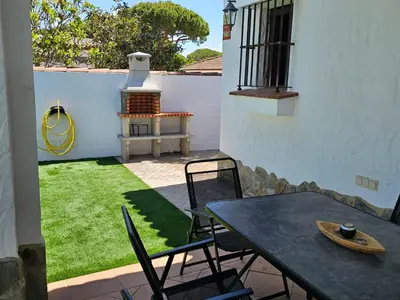 a patio with a table and chairs in a yard at Casa piscina in Chiclana de la Frontera