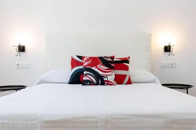 a white bed with two pillows on top of it at Bisonte A in Chiclana de la Frontera
