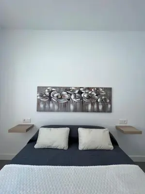 a bedroom with a bed with two pillows at GRANIZO A in Chiclana de la Frontera
