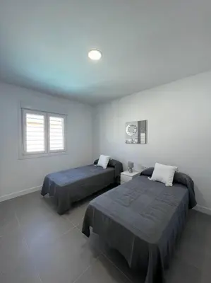 a bedroom with two beds and a window at GRANIZO A in Chiclana de la Frontera