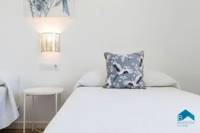 a bed with a blue pillow on top of it at Bisonte B in Chiclana de la Frontera