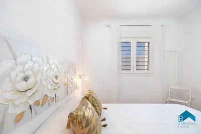 a bedroom with a bed with a flower mural on the wall at Bisonte B in Chiclana de la Frontera
