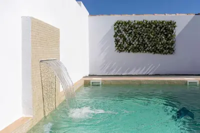 a pool with a water fountain in a building at Bisonte B in Chiclana de la Frontera