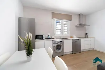 a kitchen with a washing machine and a table with chairs at Bisonte B in Chiclana de la Frontera