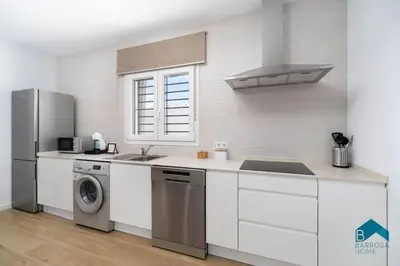 a kitchen with a sink and a washer and dryer at Bisonte C in Chiclana de la Frontera