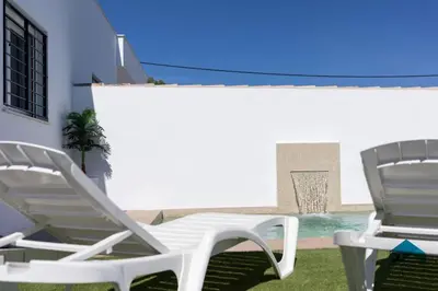two white lawn chairs sitting on the grass at Bisonte C in Chiclana de la Frontera