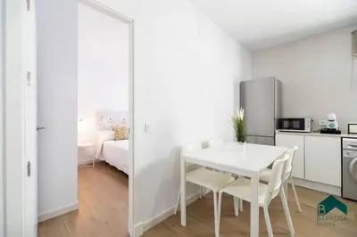 a white kitchen with a white table and a room at Bisonte C in Chiclana de la Frontera
