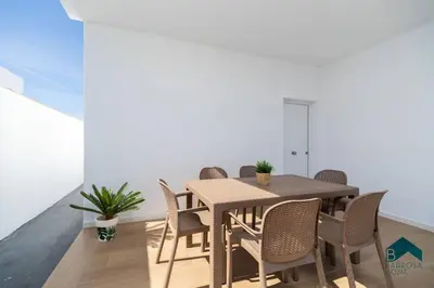 a dining room with a wooden table and chairs at Bisonte C in Chiclana de la Frontera