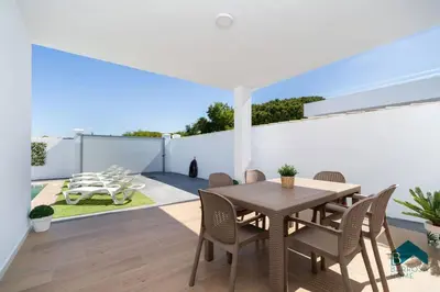 a dining room with a table and chairs on a patio at Bisonte C in Chiclana de la Frontera